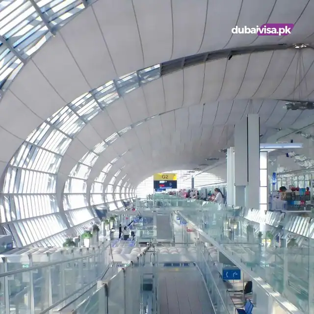 Airport terminal concourse under a curved glass roof