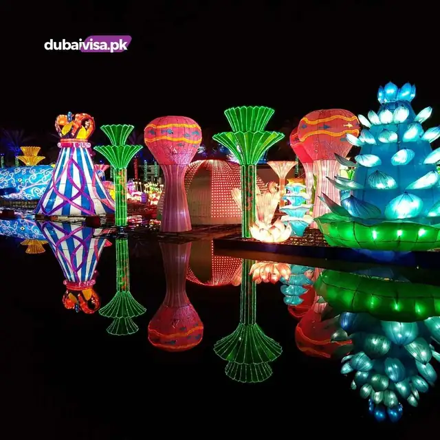 Glowing lantern sculptures reflected in water at Dubai Garden Glow at night